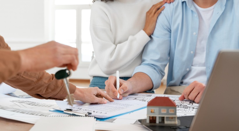 Couple signing an agreement on a property purchased at auction.