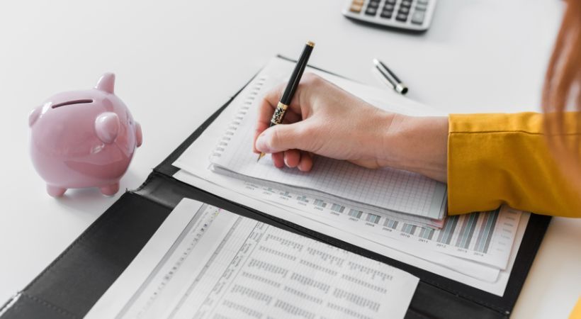 Woman working on financial documents in a binder.