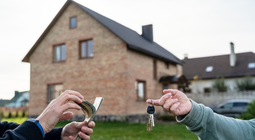Keys handed over outside a new home bought with a bridging loan after a chain break